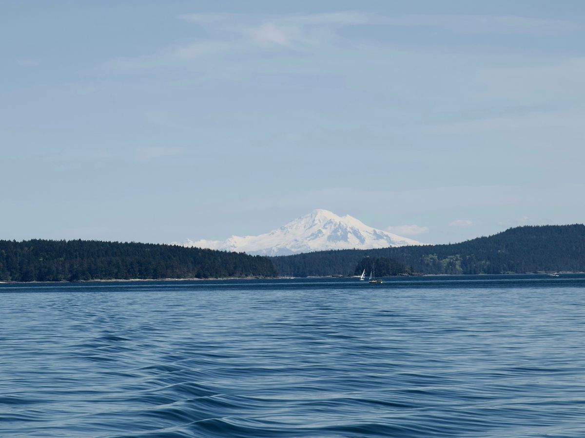 a large body of water with a mountain in the background