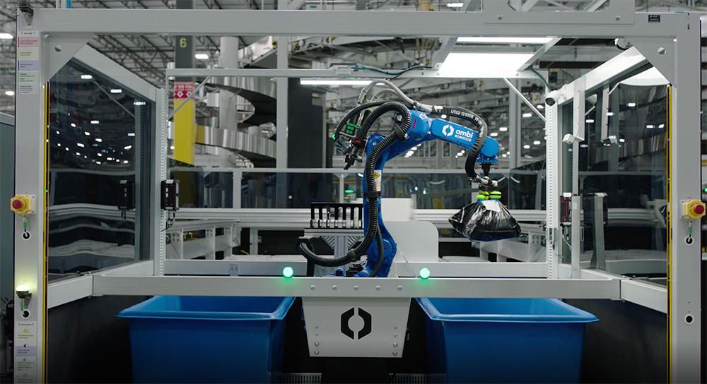 A full AmbiSort A Series system, which features a robot arm in between two blue bins all within a clear cage. 