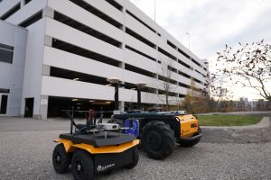 Husky A300 and Jackal with XVN integrated, in front of parking garage.