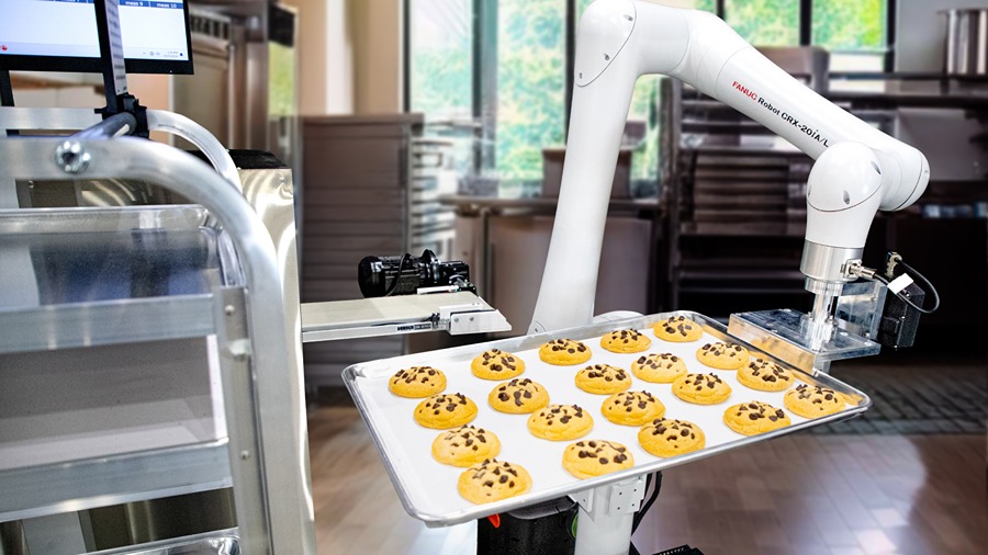 A CRX-20iA/L robot from FANUC sliding a tray of cookies onto a rack.